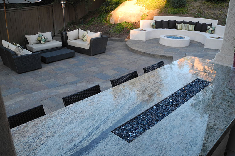 outdoor living area with firepit, built-in seating, table with fire feature