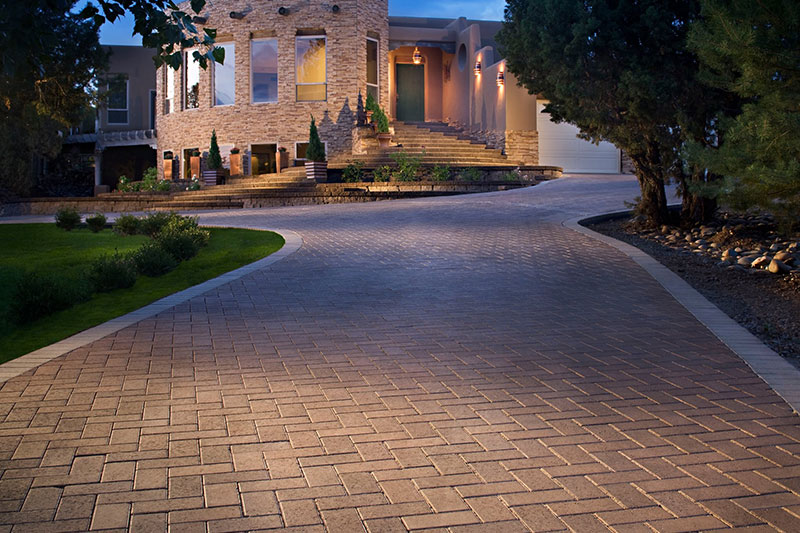 long driveway paver, brick drive with lighting and landscape leading to a luxury home