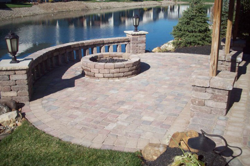 stone wall, pillars with lighting, firepit, paver patio